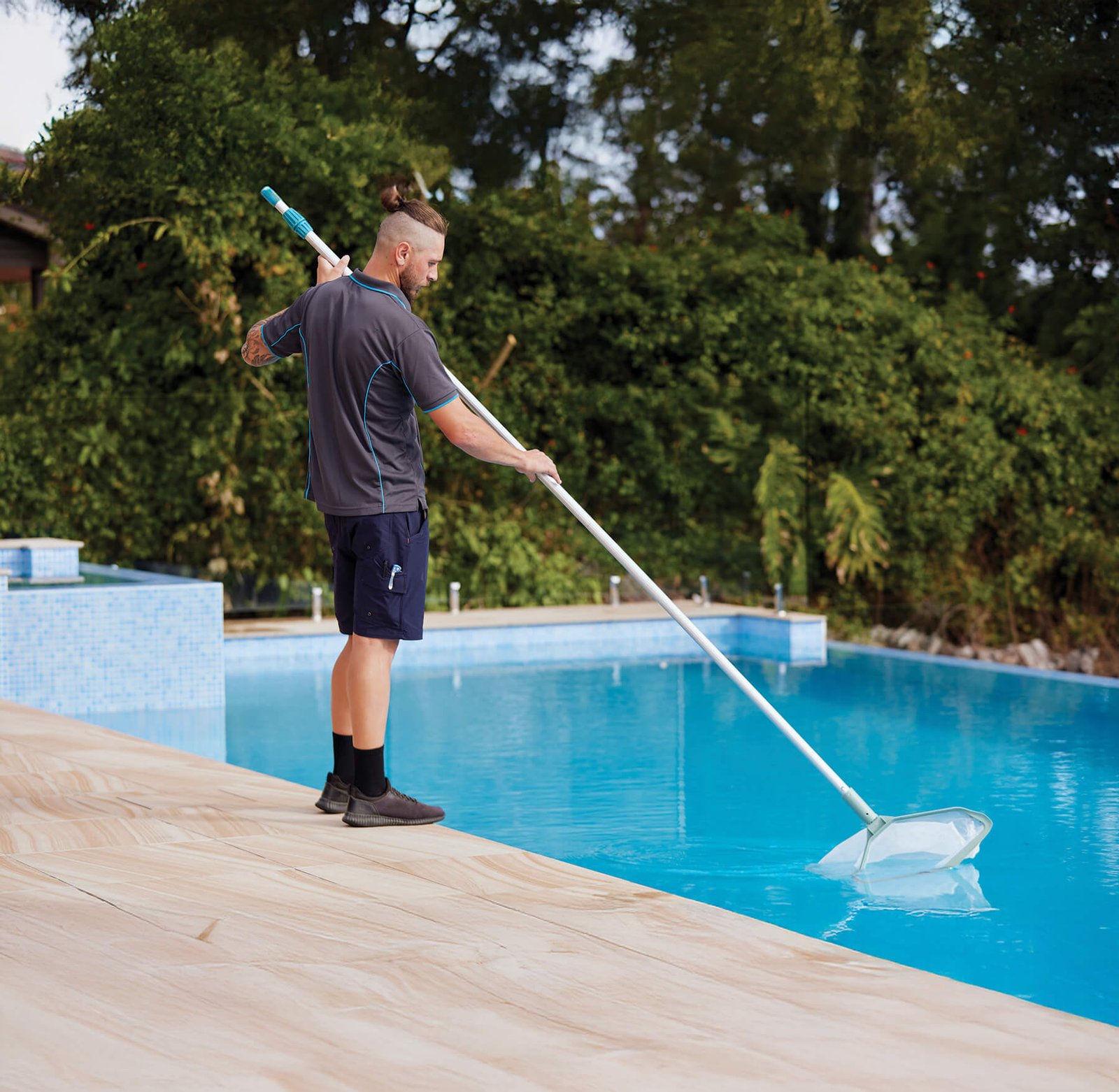 Expert technicians from Mawby's Pools performing detailed pool maintenance in a Cleveland South Euclid home